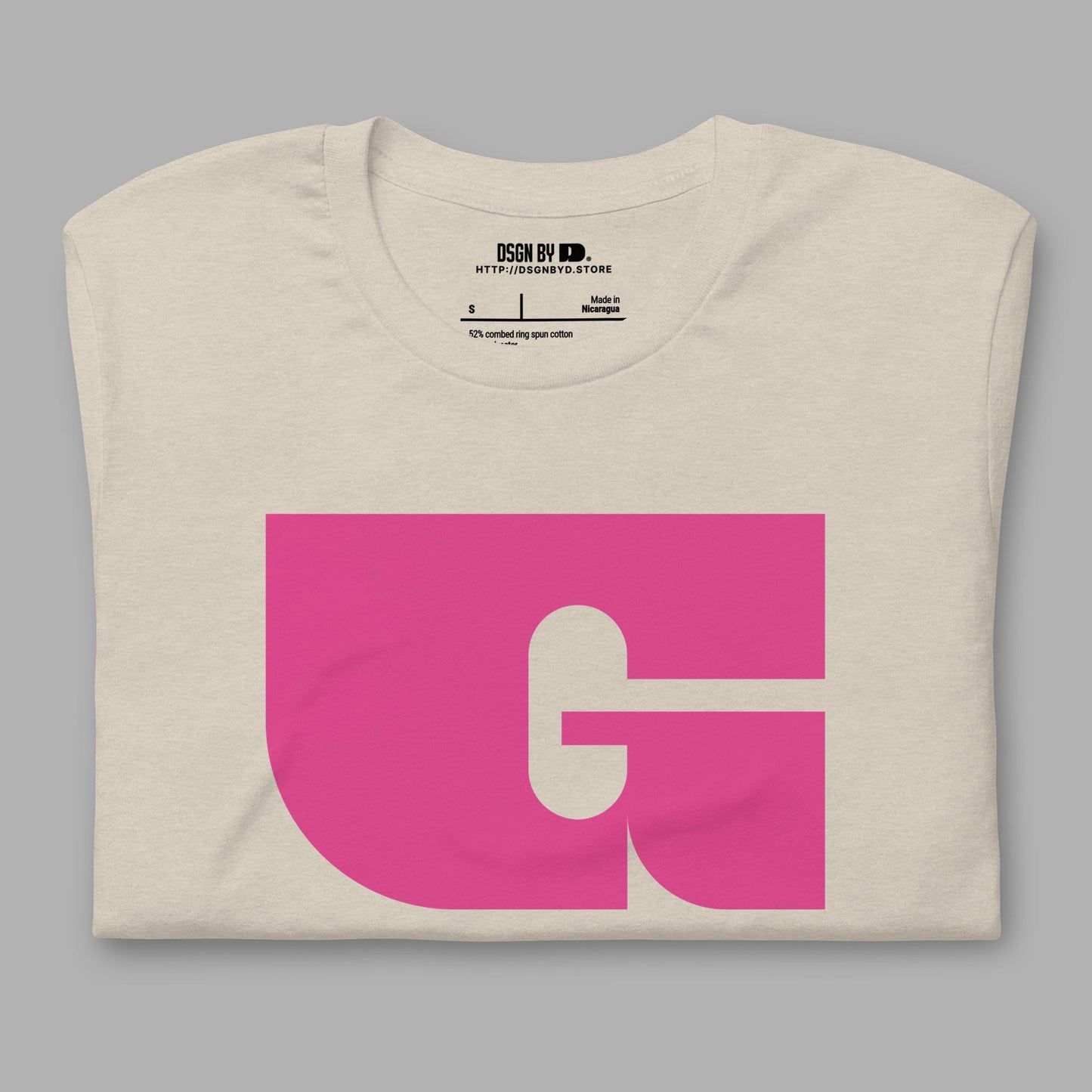 A folded beige cotton unisex graphic tee with letter G.
