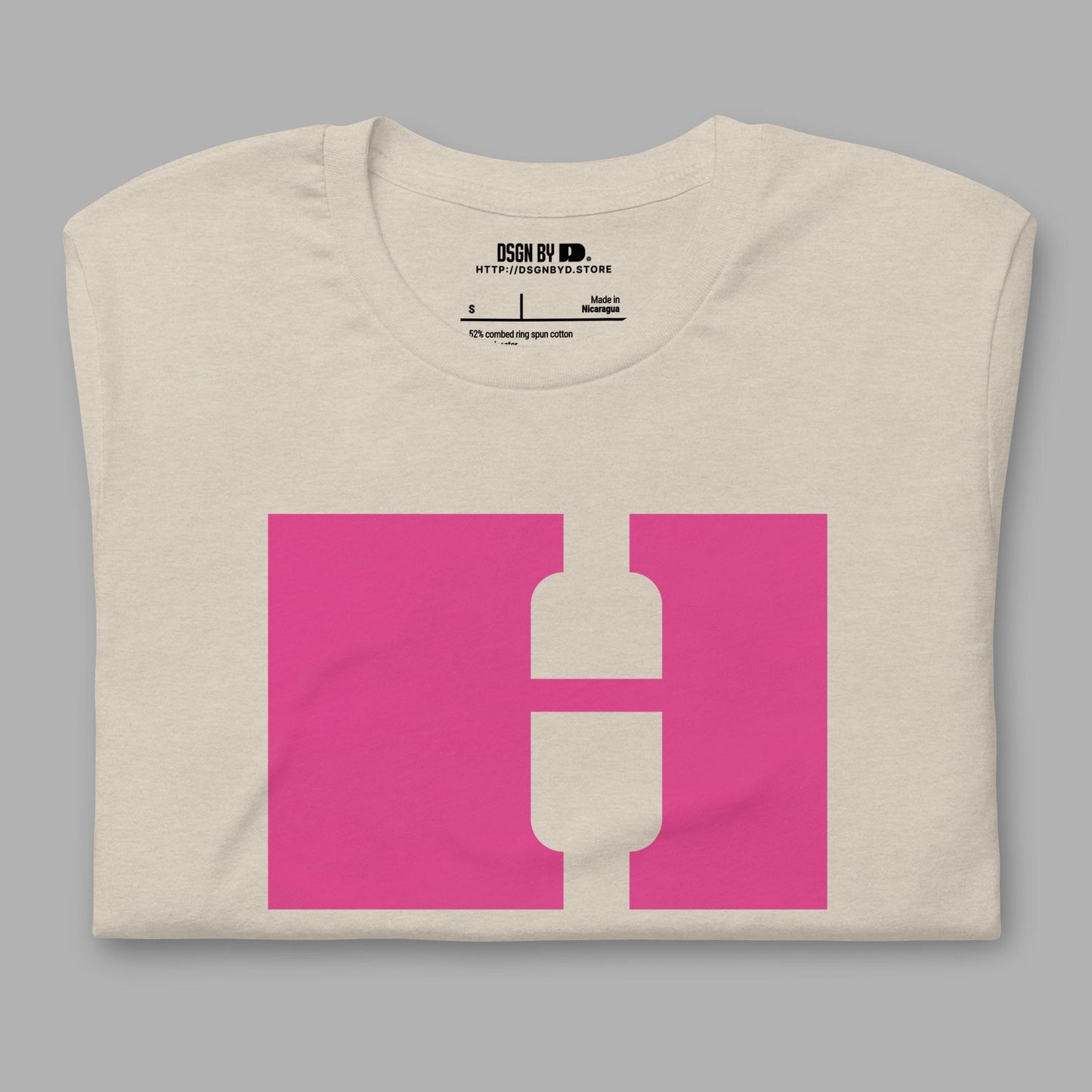 A folded beige cotton unisex graphic tee with letter H.