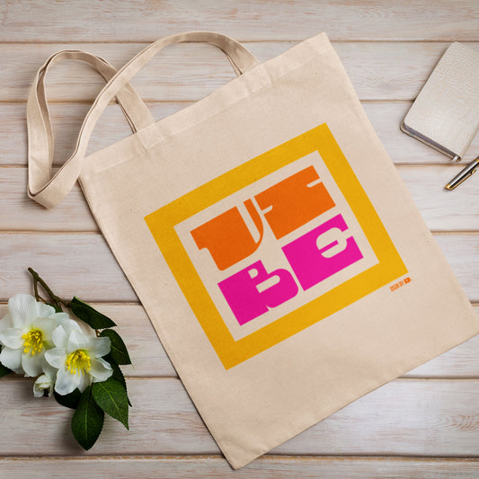 A cotton canvas tote bag with yellow, orange, and pink design.