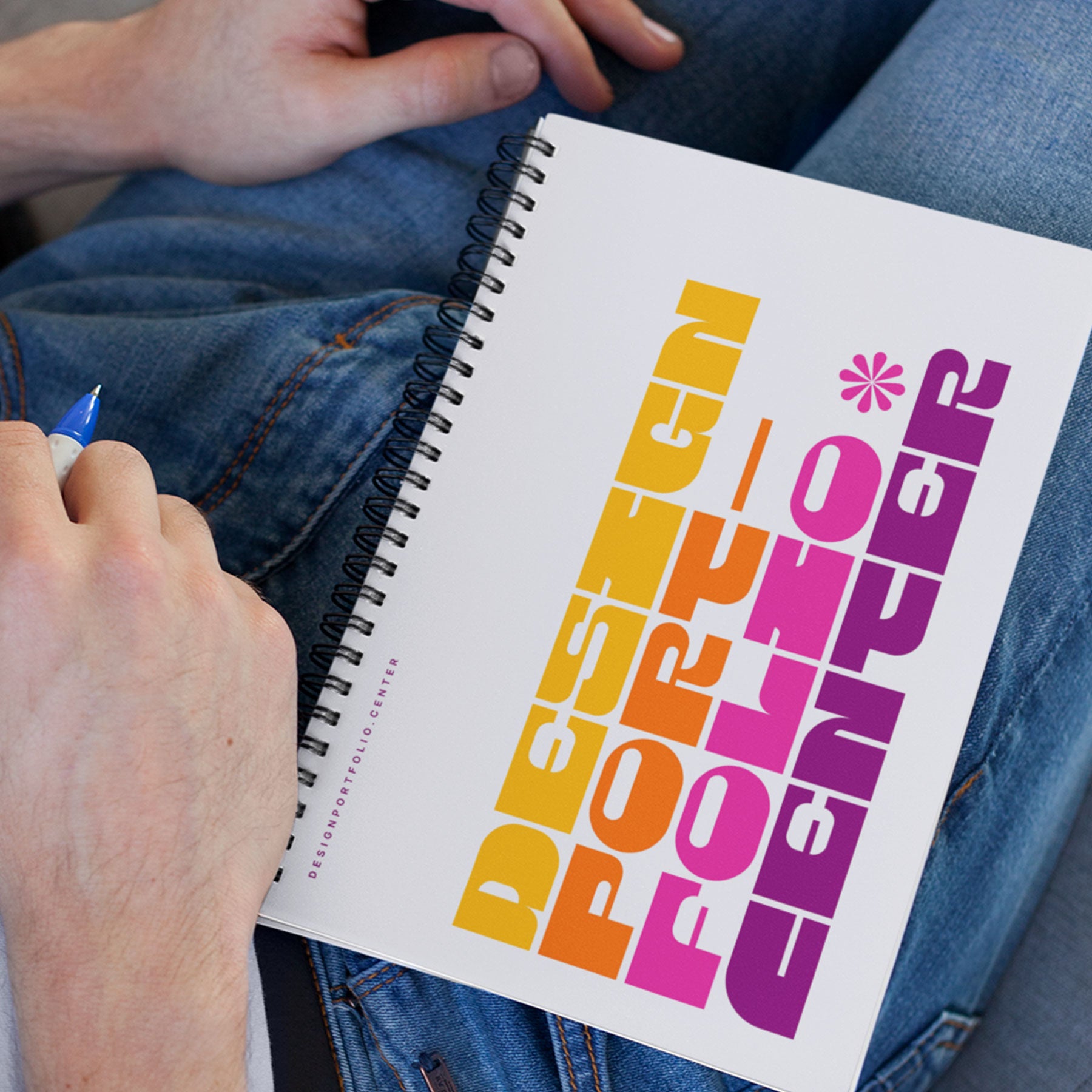 White notebook that has colorful cover showing yellow, orange, pink, and purple typography.